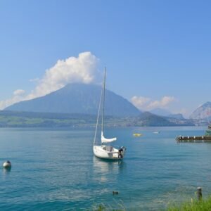 Lake Reflections - A tranquil view of Lake Thun, featuring a sailbo #18312997