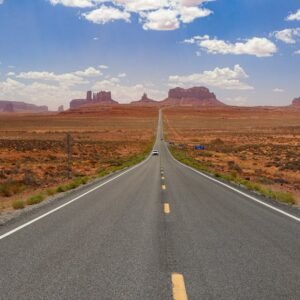 Desert Wilderness - A long, empty highway stretches through Monument #18514240