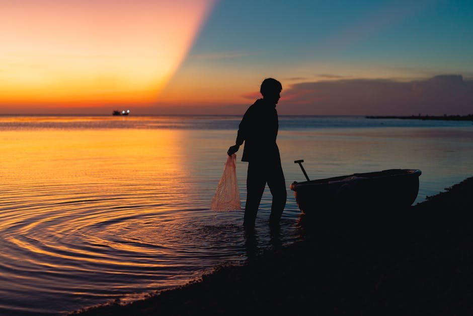 beach scenery a silhouette of a fisherman with a boat at sunse #31621071 Beach Scenery - A silhouette of a fisherman with a boat at sunse #31621071