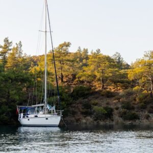Lake Reflections - A peaceful scene of a sailboat anchored near a l #5730204