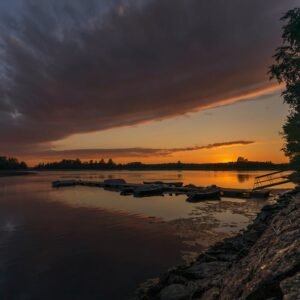 Lake Reflections - Calm lakeside at sunset with a dock silhouetted  #9245120